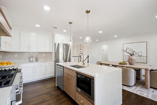 Kitchen featuring appliances with stainless steel finishes, recessed lighting, dark wood finished floors, ornamental molding, and backsplash | Image 7