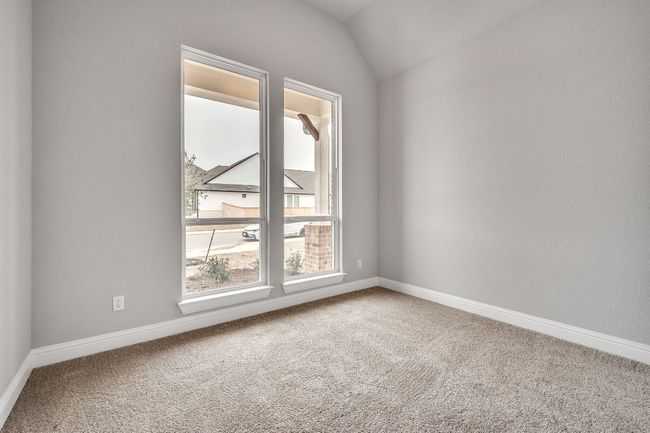 Carpeted spare room with lofted ceiling and baseboards | Image 19