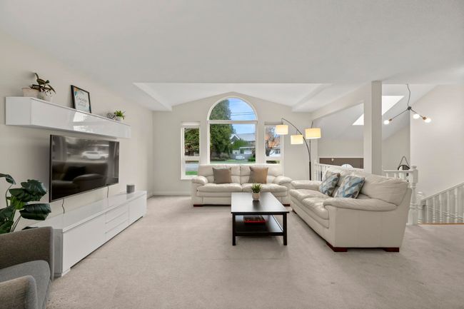 Living room featuring vaulted ceiling and light carpet | Image 7