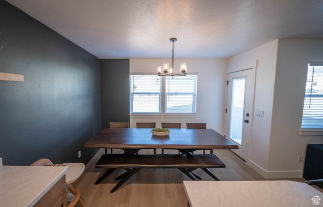 This dining space brings all the charm with a modern chandelier, a stunning accent wall, and tons of natural light. It’s the perfect spot for cozy family dinners or hosting friends. | Image 13