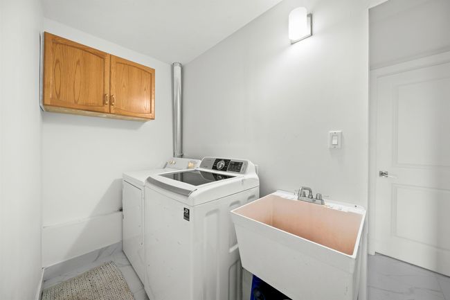 Laundry room featuring marble finish floor, a sink, cabinet space, and washer and clothes dryer | Image 23