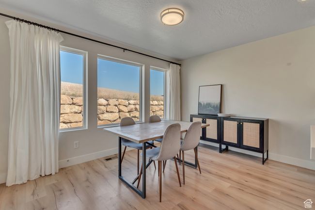 Dining room featuring light wood-type flooring and a textured ceiling | Image 10
