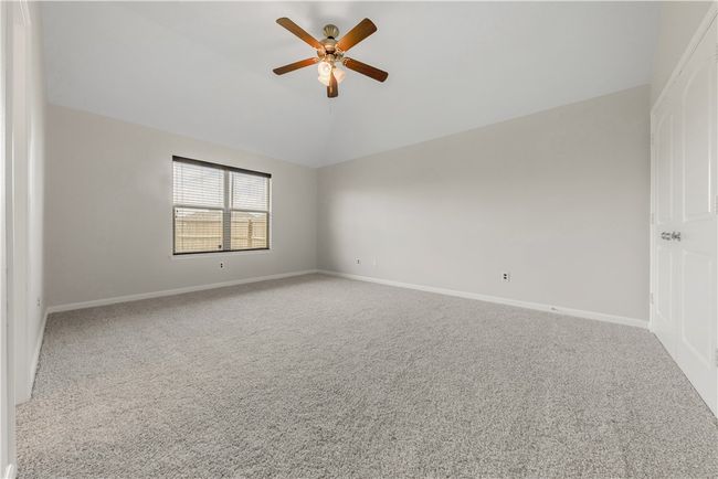 Empty room featuring carpet, a ceiling fan, vaulted ceiling, and baseboards | Image 11