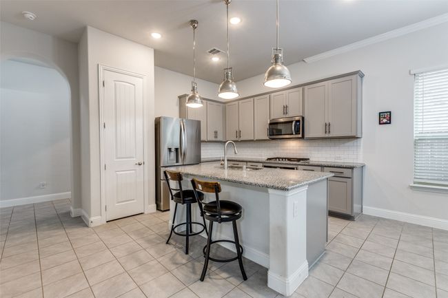 Kitchen with a sink, visible vents, appliances with stainless steel finishes, and gray cabinetry | Image 11
