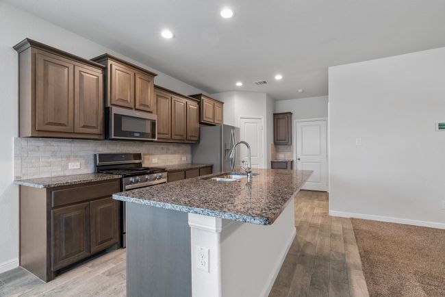 Kitchen with a sink, tasteful backsplash, stainless steel appliances, visible vents, and dark stone counters | Image 7