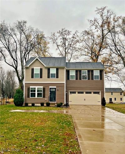 View of front facade with a front yard and a garage | Image 1