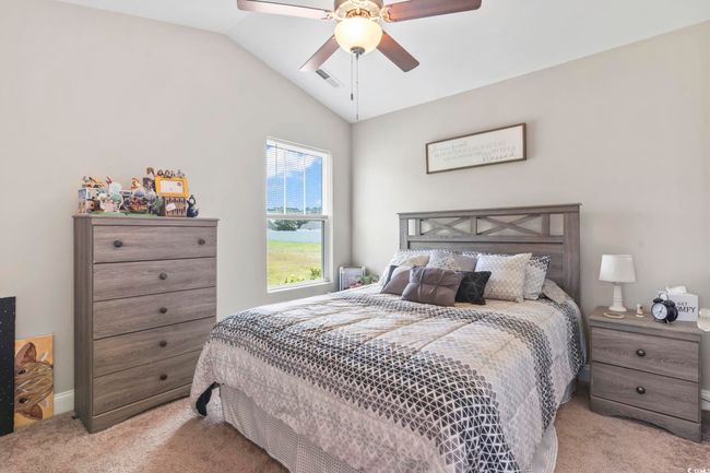 Carpeted bedroom with vaulted ceiling and a ceiling fan | Image 21