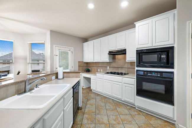There is a built-in gas cooktop, a kitchen desk space, and opens to the breakfast nook. | Image 19