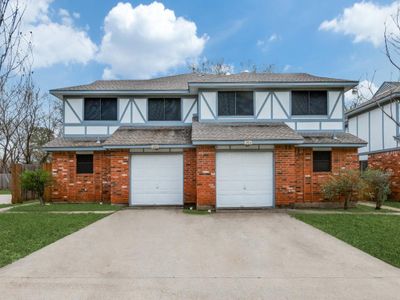 Tudor-style house featuring a front yard and a garage | Image 3