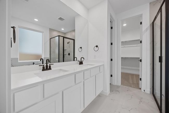 Bathroom featuring a marble finish shower, marble finish flooring, a walk in closet, double vanity, and recessed lighting | Image 13