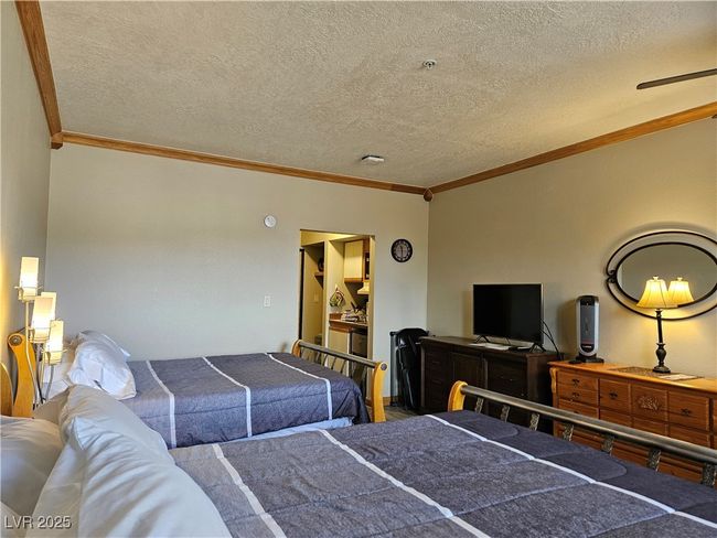 Bedroom featuring ornamental molding and a textured ceiling | Image 6