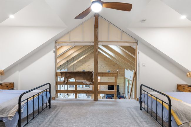 Carpeted bedroom featuring lofted ceiling, wooden walls, and ceiling fan | Image 21