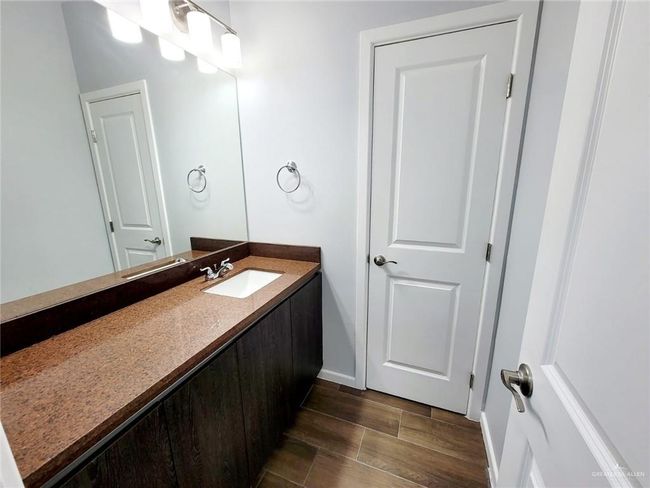 Bathroom featuring wood tiled floors, baseboards, and vanity | Image 6