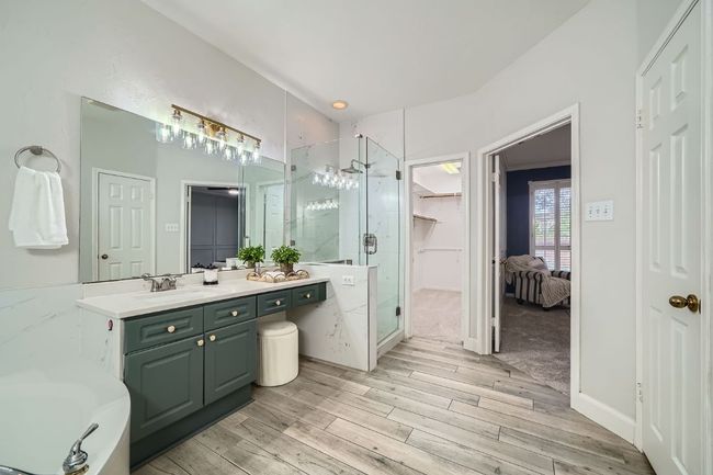 Gorgeously updated bath with quartz countertops, frameless glass shower, designer lighting & hardware | Image 21