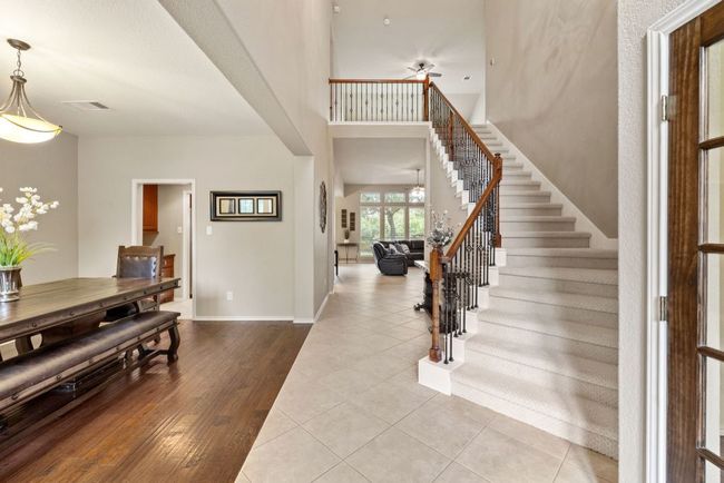 Foyer featuring stairs, a ceiling fan, wood finished floors, and a towering ceiling | Image 5