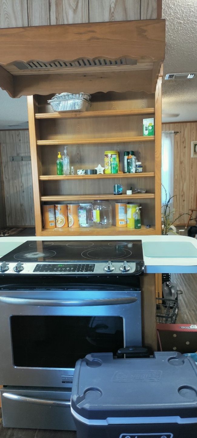 Detailed view of stainless steel electric range, a textured ceiling, and wooden walls | Image 19