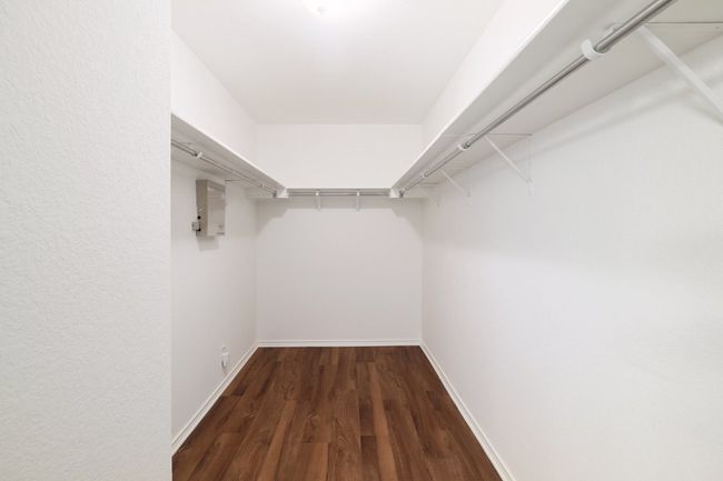 Spacious closet with dark wood finished floors | Image 24