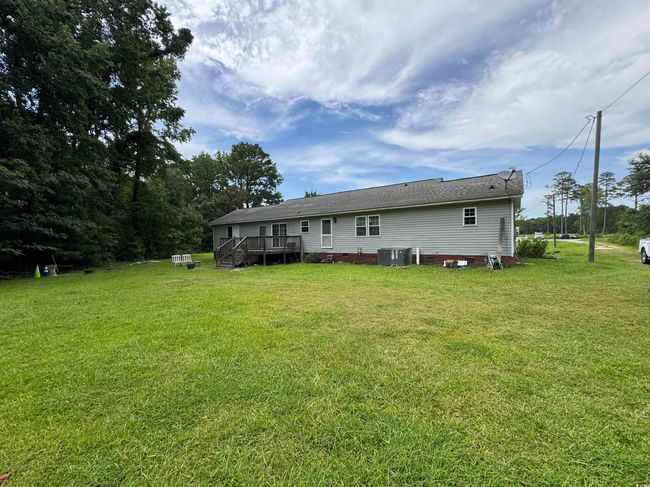 Rear view of property with a deck, a lawn, and crawl space | Image 4