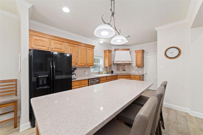 Kitchen with huge island with breakfast bar. | Image 15