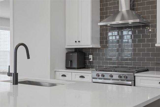 Kitchen with gas range, tiled backsplash, shaker style cabinets | Image 10