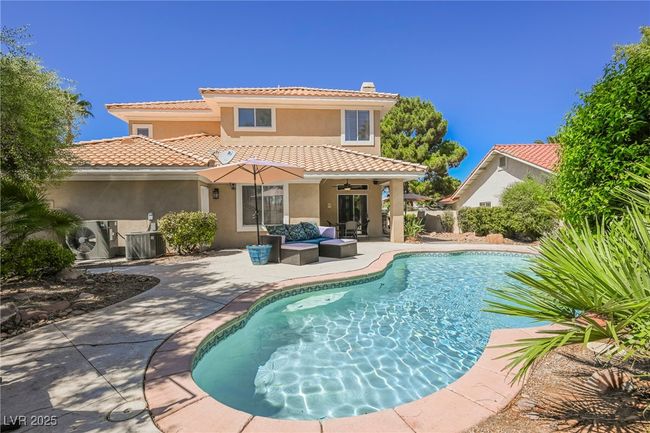 Rear view of house featuring an outdoor living space, stucco siding, a patio area, a tile roof, and an outdoor pool | Image 63