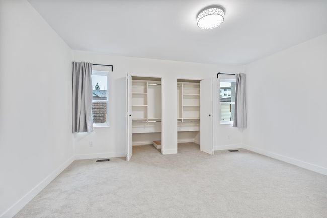 Unfurnished bedroom with visible vents, multiple closets, carpet, and baseboards | Image 13
