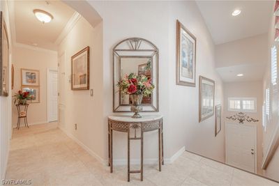 Corridor featuring ornamental molding, lofted ceiling, and light tile floors | Image 3