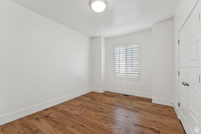 Unfurnished bedroom with wood-type flooring and a closet | Image 17