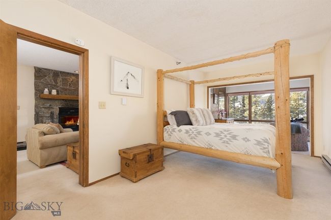 Bedroom featuring light colored carpet and a fireplace | Image 11