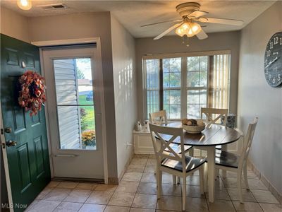 Tiled dining room with ceiling fan and a textured ceiling | Image 3