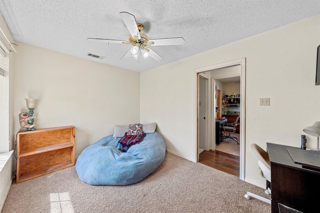 Bedroom with a ceiling fan, a textured ceiling, visible vents, and carpet | Image 21