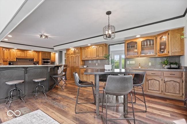 kitchen featuring stainless steel oven, recessed lighting, backsplash, glass insert cabinets, and dark wood-type flooring | Image 14