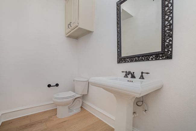 Bathroom with toilet, wood finished floors, and baseboards | Image 10