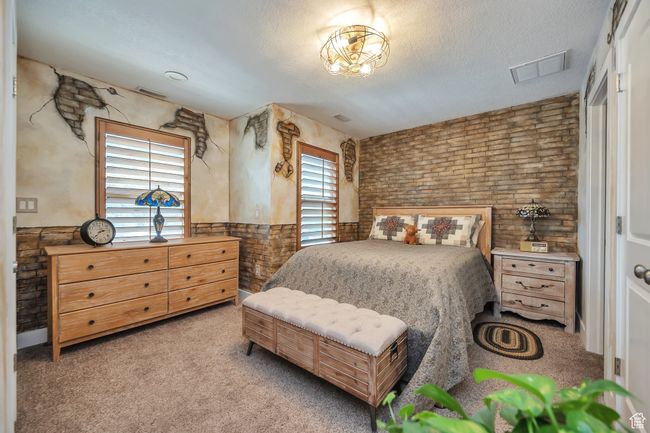 Carpeted bedroom featuring visible vents, wainscoting, and a textured ceiling | Image 15