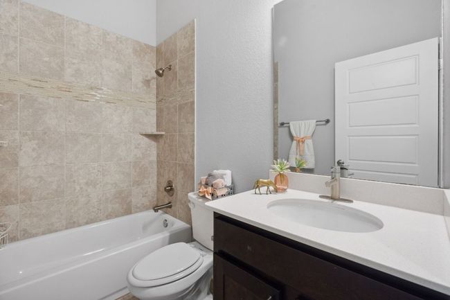 Full bath featuring shower/bath combination, accented glass tile, and roomy vanity | Image 30