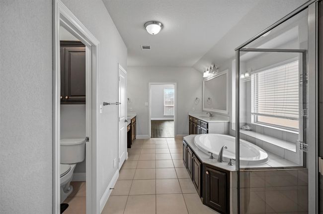 Bathroom featuring tile patterned flooring, visible vents, toilet, a garden tub, and vanity | Image 31