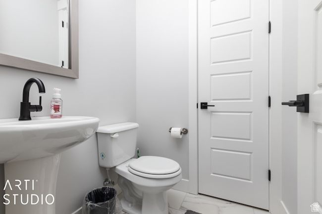 Bathroom with a sink, baseboards, toilet, and marble finish floor | Image 21