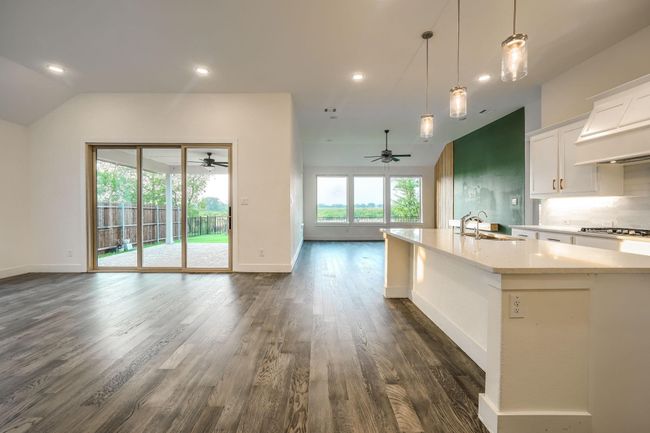 Kitchen with ceiling fan, open floor plan, a sink, dark wood-type flooring, and vaulted ceiling | Image 6