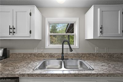 Kitchen featuring white cabinets, dishwasher, a textured ceiling, and sink | Image 3