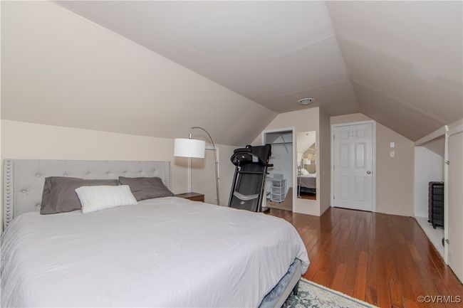 Bedroom with wood-type flooring, vaulted ceiling, a spacious closet, and a closet | Image 26