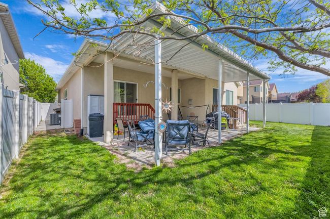 Back of house featuring a fenced backyard, stucco siding, a patio, cooling unit, and a lawn | Image 28