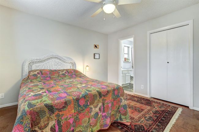 Bedroom with baseboards, connected bathroom, wood finished floors, and ceiling fan | Image 18