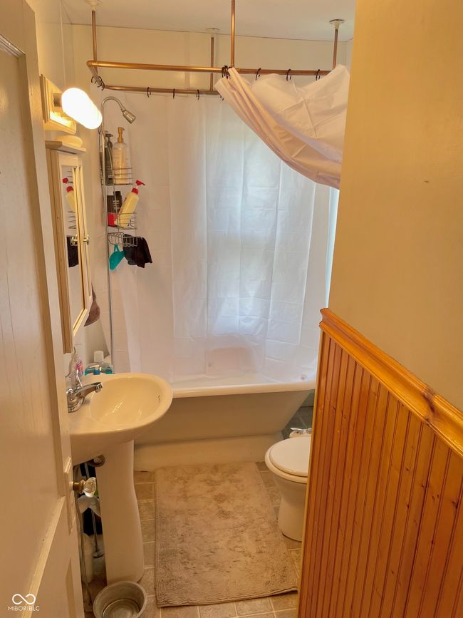 full bath featuring shower / bathtub combination with curtain, toilet, and tile patterned flooring | Image 16