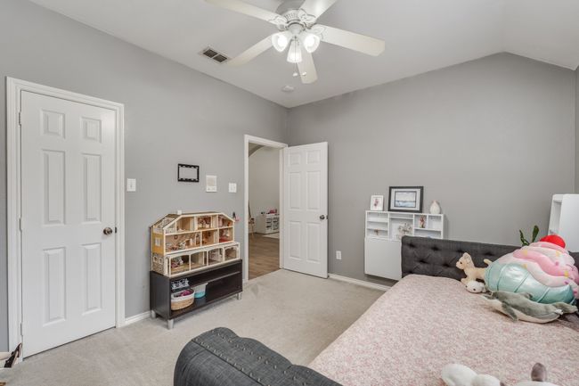 Bedroom featuring carpet floors, ceiling fan, baseboards, and vaulted ceiling | Image 13
