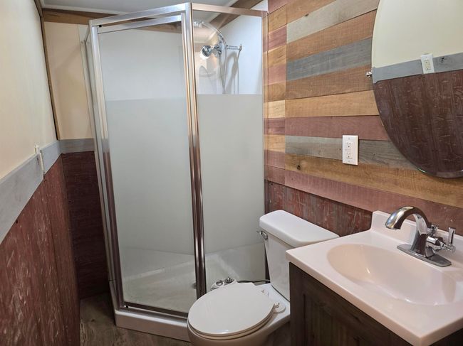 Bathroom featuring vanity, toilet, and a shower with shower door | Image 12