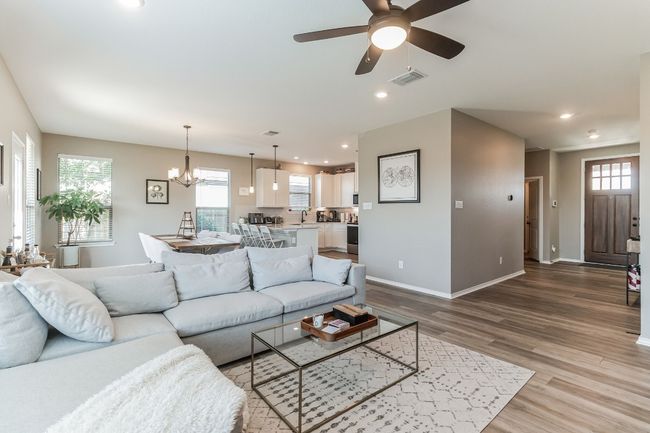 Living area with plenty of natural light, light wood-style flooring, a chandelier, ceiling fan, and recessed lighting | Image 7