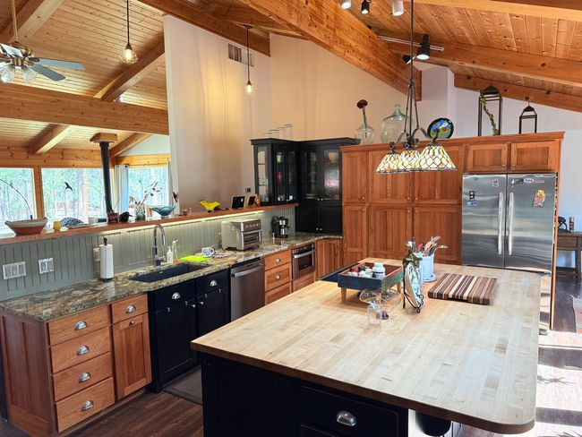 Kitchen featuring stainless steel appliances, vaulted tongue & groove ceiling with beams, and custom Mission style cabinets | Image 10