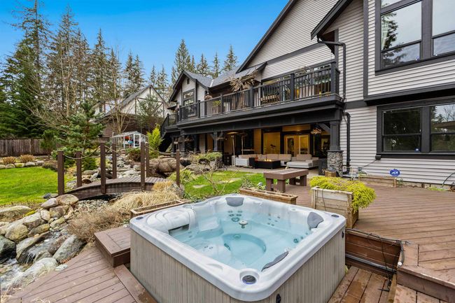 Wooden terrace featuring a hot tub and an outdoor living space | Image 33