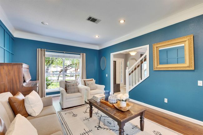 Living area with wood finished floors, ornamental molding, stairs, recessed lighting, and baseboards | Image 13