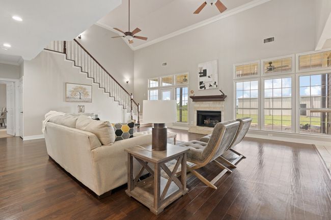 Living area, two ceiling fans, Austin stone gas fireplace, natural light | Image 12